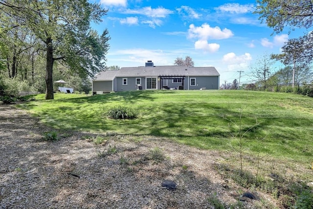 back of property with a lawn and a chimney