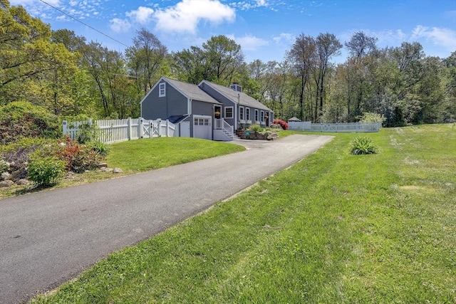 view of front of property with driveway, a garage, and a chimney