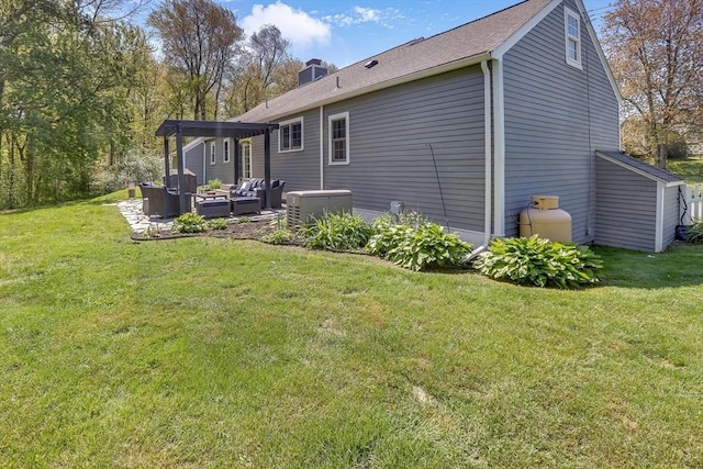 rear view of property with an outdoor living space, a patio area, a lawn, and a chimney