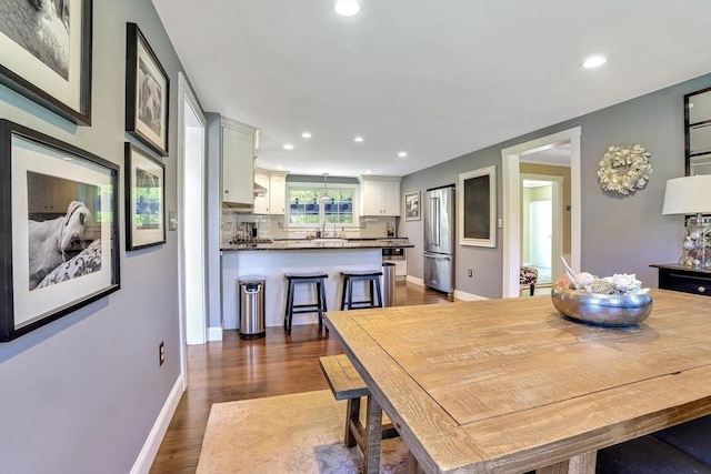 dining space featuring recessed lighting, dark wood finished floors, and baseboards