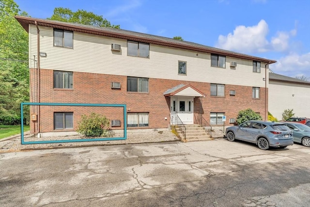 50 Juniper Rd Unit 1C, North Attleboro, MA 02760 - view of front of house featuring brick siding, uncovered parking, and a wall mounted AC