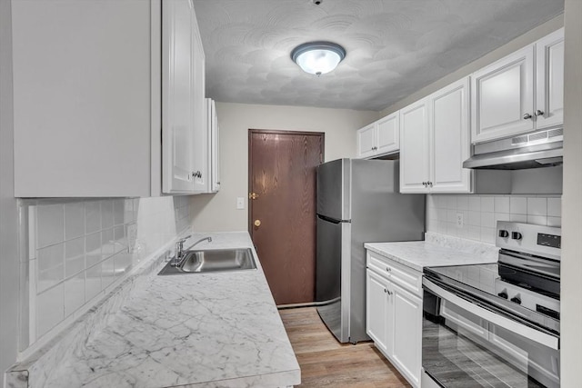 50 Juniper Rd Unit 1C, North Attleboro, MA 02760 - kitchen featuring appliances with stainless steel finishes, under cabinet range hood, a sink, white cabinetry, and light countertops