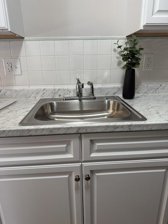 50 Juniper Rd Unit 1C, North Attleboro, MA 02760 - kitchen view of a sink, backsplash, and white cabinets