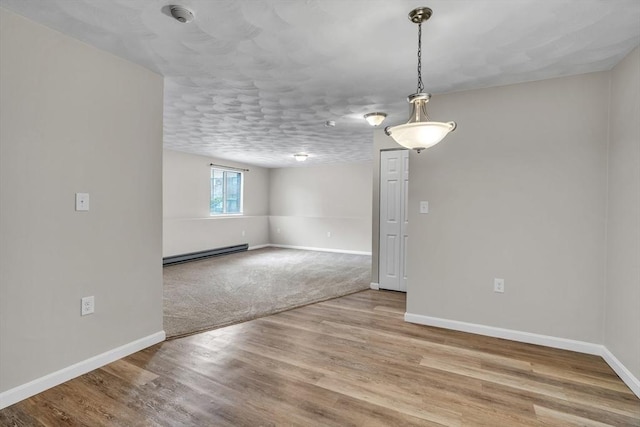 50 Juniper Rd Unit 1C, North Attleboro, MA 02760 - spare room featuring a baseboard heating unit, baseboards, a smoke detector, and wood finished floors
