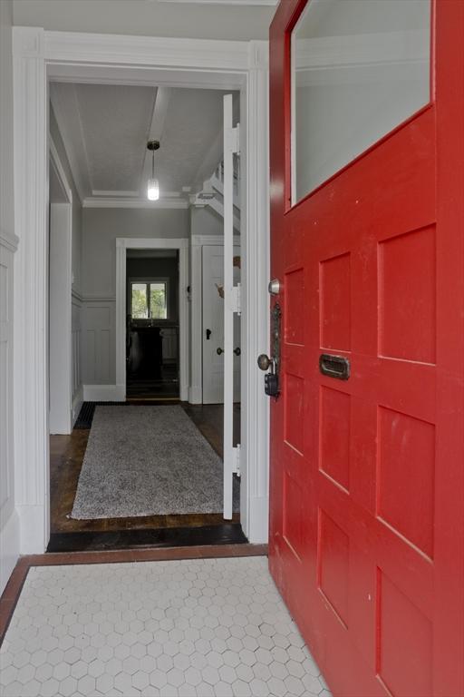 entrance foyer with ornamental molding, ceiling fan, beamed ceiling, and hardwood / wood-style floors