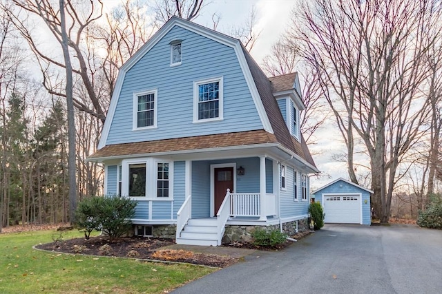 dutch colonial with an outbuilding, aphalt driveway, a shingled roof, a detached garage, and a gambrel roof