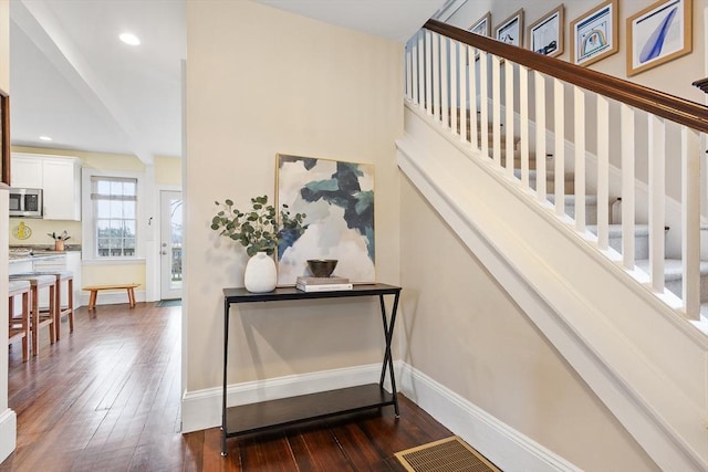 staircase with recessed lighting, wood finished floors, visible vents, and baseboards