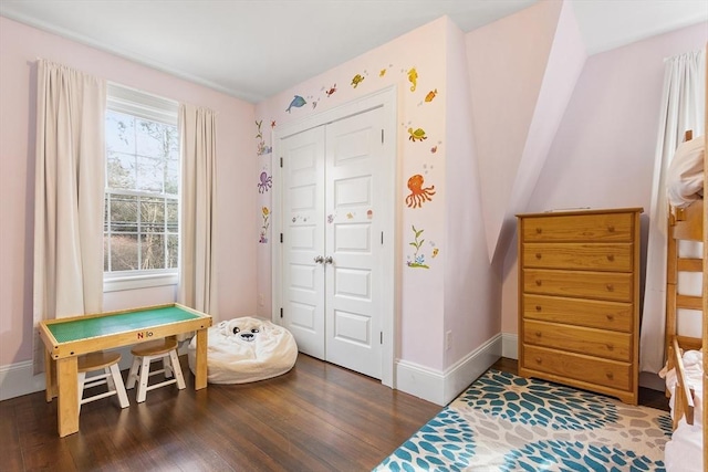 bedroom featuring dark wood-style floors, a closet, and baseboards