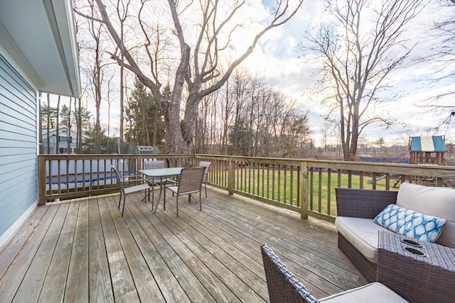 wooden terrace with a yard and outdoor dining space