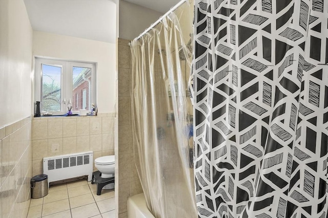 bathroom with tile patterned floors, radiator heating unit, toilet, and tile walls