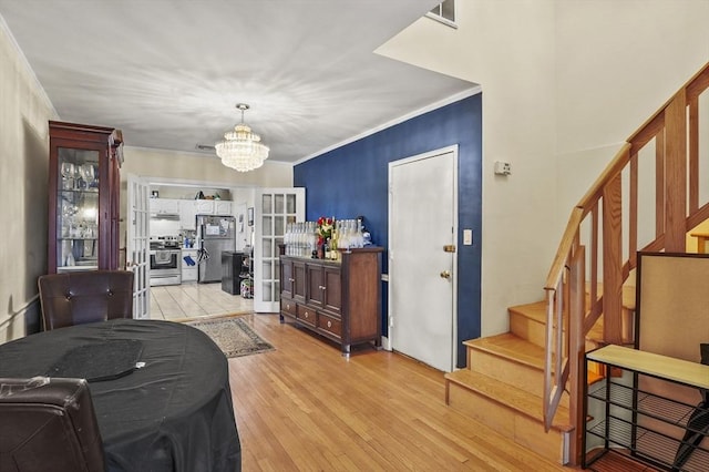 dining room featuring a notable chandelier, ornamental molding, and light hardwood / wood-style floors