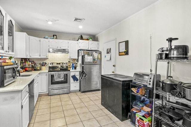 kitchen with light tile patterned flooring, white cabinetry, crown molding, tasteful backsplash, and stainless steel appliances