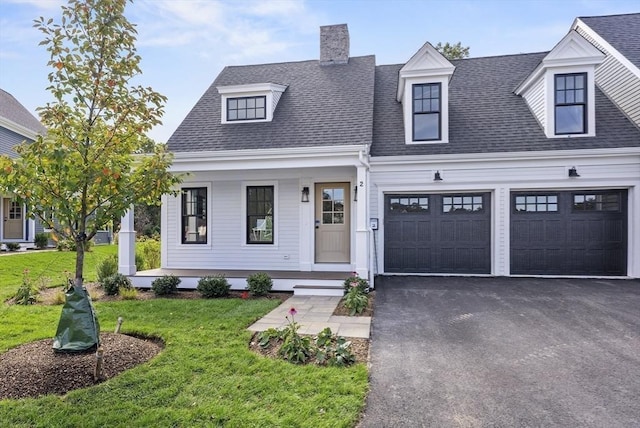 view of front of home featuring a garage, a front lawn, and a porch