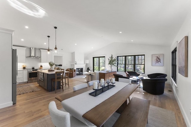 dining room with vaulted ceiling and light hardwood / wood-style flooring