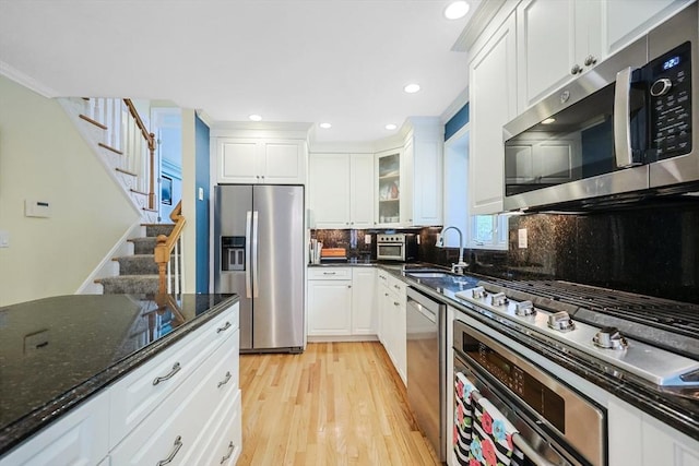 8 Rock Rd, Attleboro, MA 02703 - kitchen with appliances with stainless steel finishes, a sink, white cabinets, light wood finished floors, and tasteful backsplash
