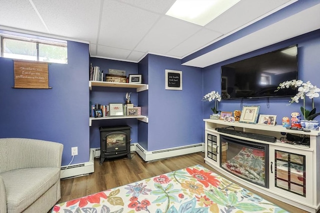 8 Rock Rd, Attleboro, MA 02703 - living area featuring a wood stove, wood finished floors, baseboard heating, and a drop ceiling