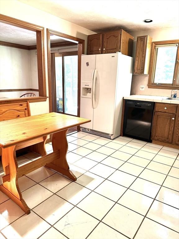 117 Metropolitan Ave Unit 117, Ashland, MA 01721 - kitchen featuring black dishwasher, white fridge with ice dispenser, light countertops, and light tile patterned floors