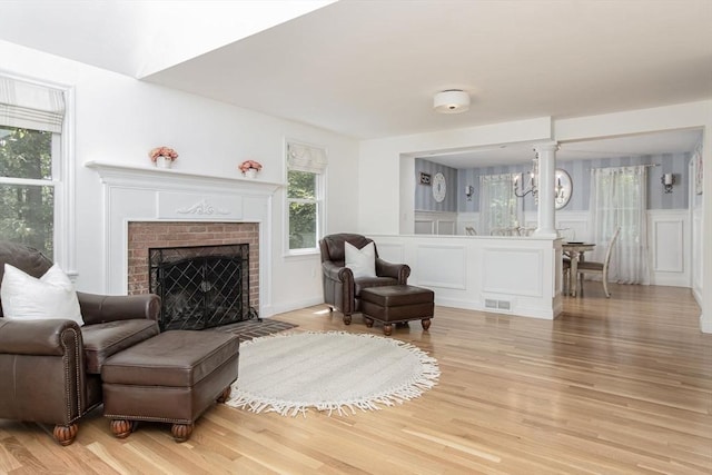 8 Whitaker Ln, Groton, MA 01450 - living room featuring light wood-style floors, a decorative wall, and a brick fireplace