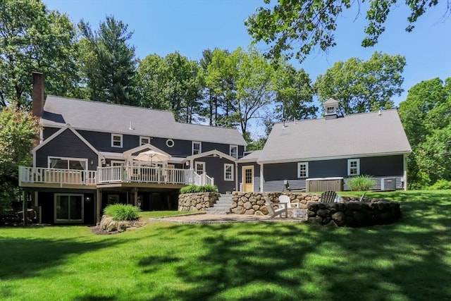 8 Whitaker Ln, Groton, MA 01450 - rear view of property featuring a wooden deck, a lawn, and a chimney