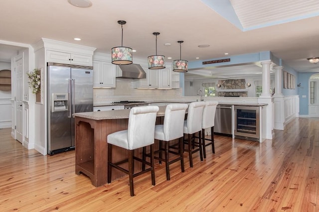 8 Whitaker Ln, Groton, MA 01450 - kitchen with appliances with stainless steel finishes, wall chimney exhaust hood, wine cooler, light wood-style flooring, and recessed lighting
