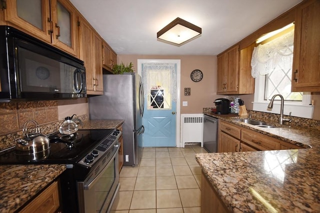 kitchen featuring radiator heating unit, glass insert cabinets, black microwave, a sink, and range with electric stovetop