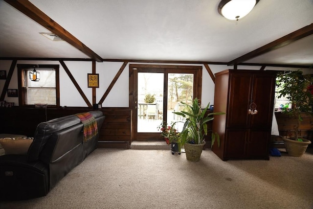 living room featuring carpet floors and beamed ceiling