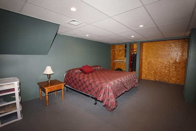 bedroom with a paneled ceiling, concrete floors, visible vents, and recessed lighting