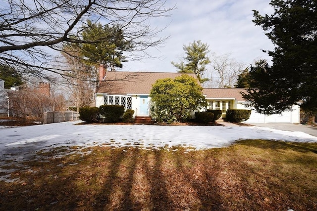 view of front of home with a garage, driveway, and a chimney