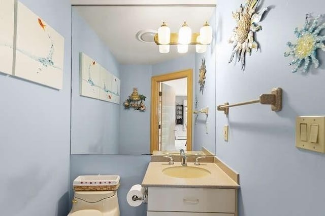 half bathroom featuring vanity and toilet