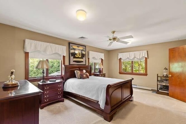 bedroom with light carpet, multiple windows, and a baseboard radiator