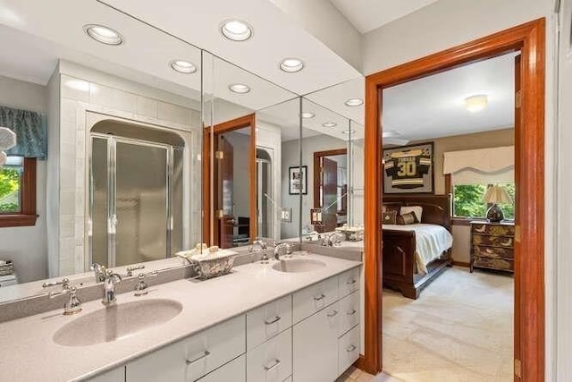 bathroom featuring a sink, double vanity, a stall shower, and recessed lighting