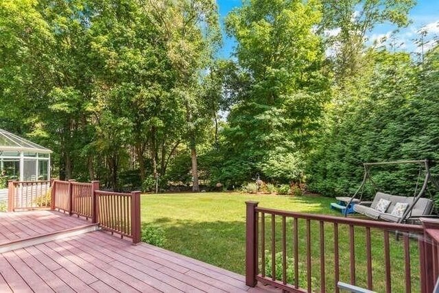 deck featuring a lanai and a lawn