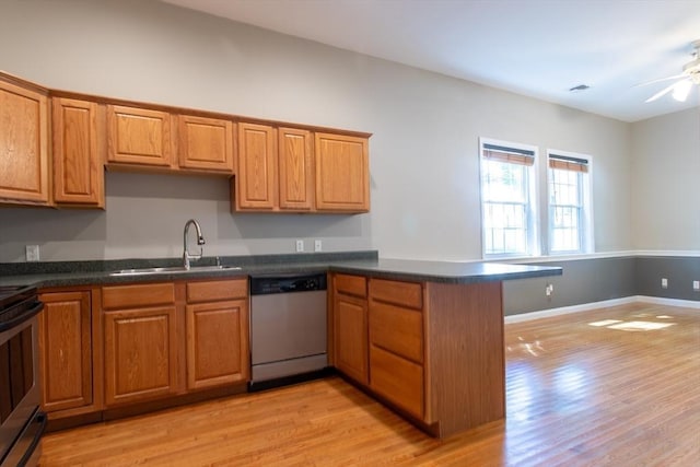 31-33 Ashland St Unit 5, Haverhill, MA 01830 - kitchen with appliances with stainless steel finishes, a sink, light wood-type flooring, dark countertops, and a peninsula
