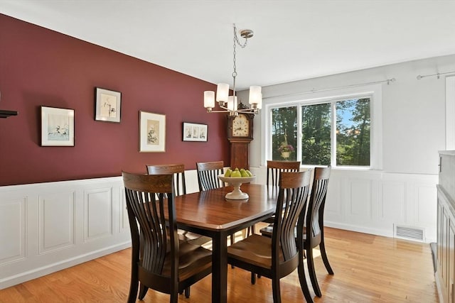 9 E Colonial Rd, Wilbraham, MA 01095 - dining space featuring a decorative wall, a wainscoted wall, a chandelier, and light wood finished floors
