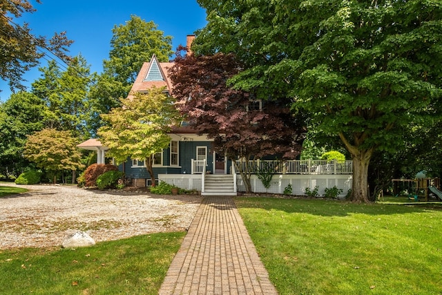 obstructed view of property with a playground and a front yard