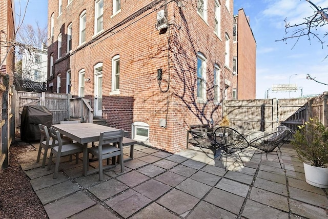 view of patio / terrace with outdoor dining space, a fenced backyard, and grilling area