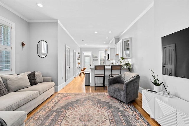 living area featuring light wood-style floors, a healthy amount of sunlight, and baseboards