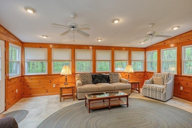 sunroom featuring vaulted ceiling, wood walls, recessed lighting, and a textured ceiling