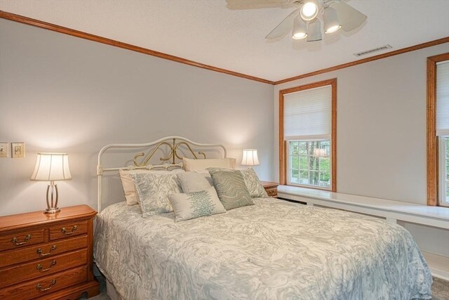 carpeted bedroom featuring ornamental molding and ceiling fan