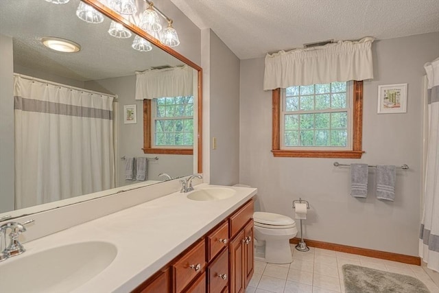 bathroom featuring a textured ceiling, plenty of natural light, tile patterned floors, toilet, and baseboards