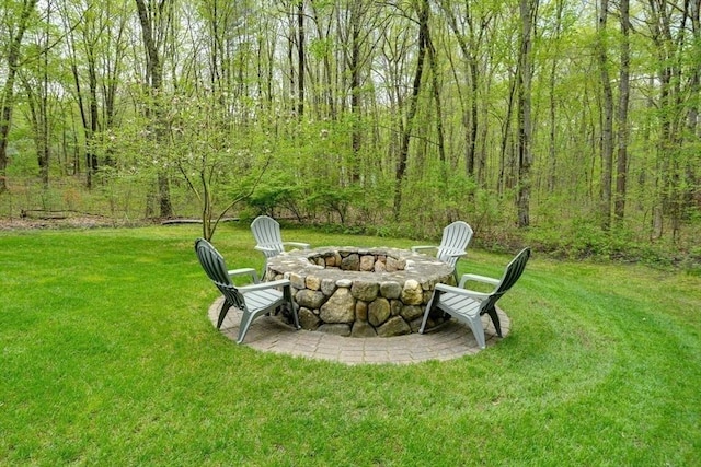 view of grassy yard with a fire pit
