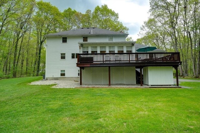 back of house with a deck and a yard
