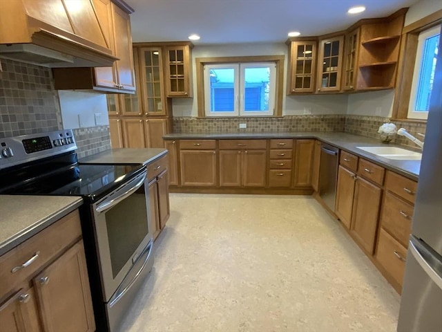 kitchen featuring wall chimney exhaust hood, appliances with stainless steel finishes, sink, and plenty of natural light