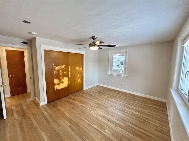 unfurnished bedroom featuring ceiling fan, light wood-type flooring, and a closet