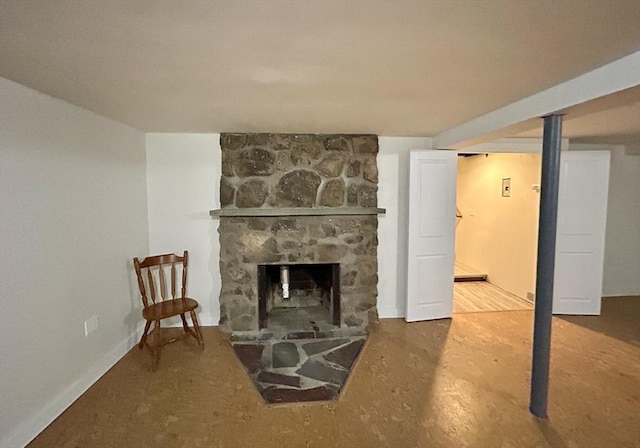 interior space featuring a stone fireplace and concrete flooring