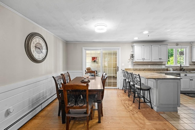 77 Columbus Dr, Fall River, MA 02720 - dining area featuring a baseboard radiator, crown molding, a wainscoted wall, and light wood-type flooring