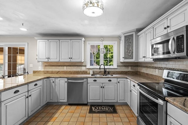 77 Columbus Dr, Fall River, MA 02720 - kitchen featuring stainless steel appliances, a sink, ornamental molding, light tile patterned floors, and tasteful backsplash