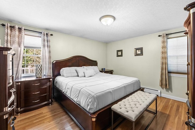 77 Columbus Dr, Fall River, MA 02720 - bedroom featuring a baseboard radiator, wood finished floors, a textured ceiling, and baseboards