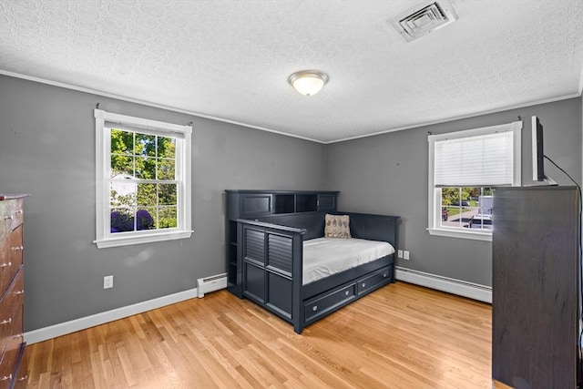 77 Columbus Dr, Fall River, MA 02720 - bedroom with a baseboard heating unit, light wood-style flooring, and baseboards