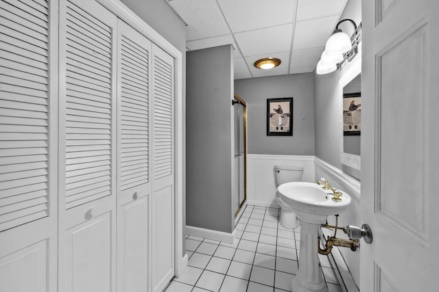 77 Columbus Dr, Fall River, MA 02720 - full bathroom with a closet, a stall shower, tile patterned floors, a paneled ceiling, and wainscoting